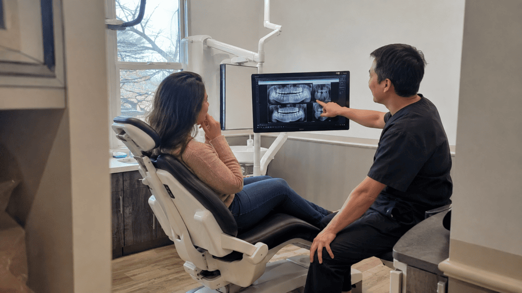 Dentist reviewing dental concerns with a patient while discussing which problems may need prompt treatment.
